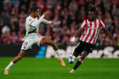 PSG's Bradley Barcola, left, and Athletic Bilbao's Nico Williams challenge for the ball during of the Champions League opening phase soccer match between Athletic Bilbao and PSG in Bilbao, Spain.