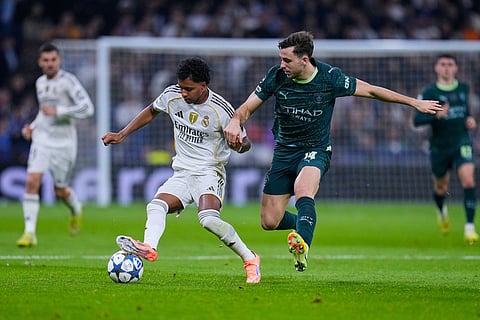 Real Madrid's Rodrygo, left, tussles for the ball with Manchester City's Nico Gonzalez during a Champions League opening phase soccer match between Real Madrid and Manchester City, in Madrid, Spain.