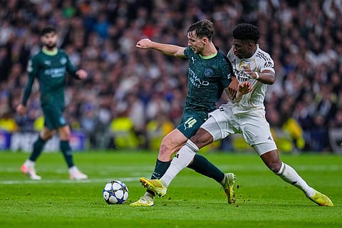 Manchester City's Nico Gonzalez, left, vies for the ball with Real Madrid's Aurelien Tchouameni during a Champions League opening phase soccer match between Real Madrid and Manchester City, in Madrid, Spain.