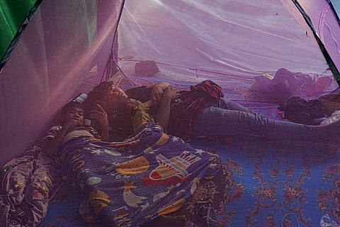 Young boys sleep in a mosquito net as they take refuge at Wat Chroy Neangoun's Buddhist pagoda in Siem Reap province, Cambodia after fleeing from home following fighting between Thailand and Cambodia over territorial claims. 
