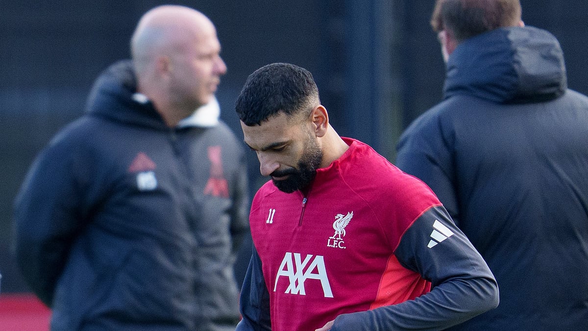 | Photo: AP/Jon Super : Liverpool's Mohamed Salah passes manager Arne Slot as he takes part in a training session on December 8, 2025.
