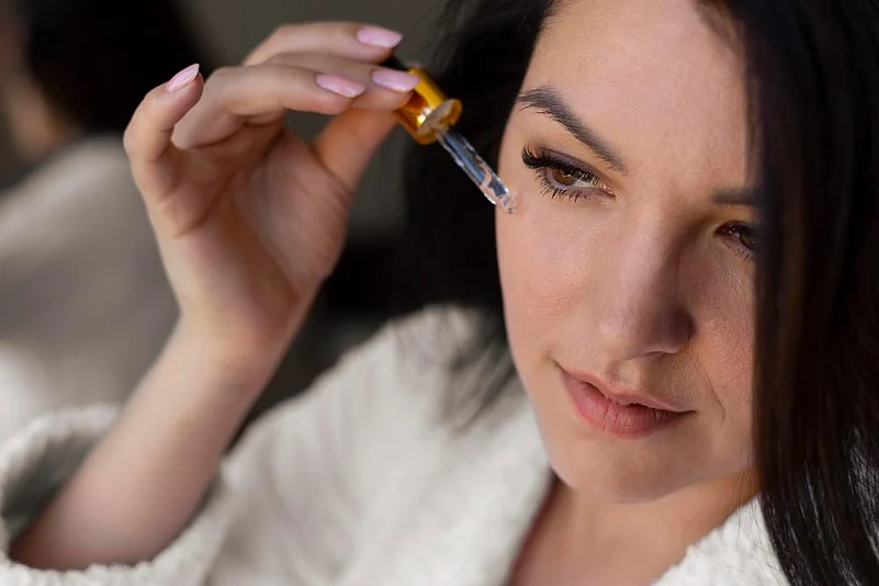 A woman applying niacinamide serum