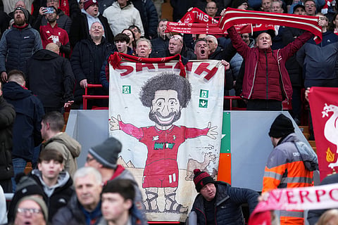 Liverpool fans hold placard depicting Liverpool's Mohamed Salah before the English Premier League soccer match between Liverpool and Brighton and Hove Albion in Liverpool, England.