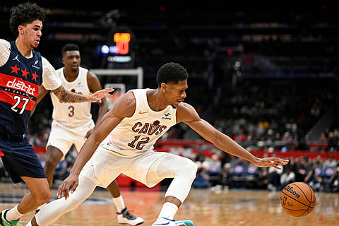 Cleveland Cavaliers forward De'Andre Hunter, right, reaches for the ball against Washington Wizards guard Will Riley, left, during the first half of an NBA basketball game in Washington. 