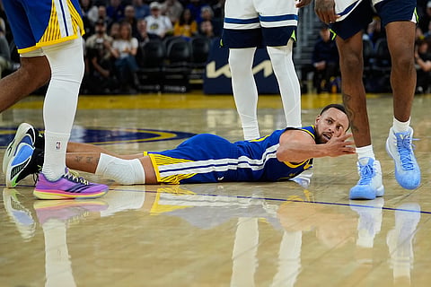 Golden State Warriors guard Stephen Curry, center, reacts during the second half of an NBA basketball game against the Minnesota Timberwolves in San Francisco. 