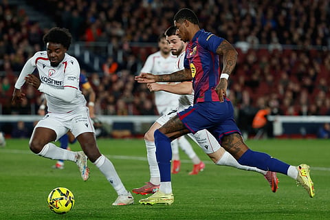Osasuna's Enzo Boyomo guards Barcelona's Marcus Rashford during a La Liga soccer match between Barcelona and Osasuna in Barcelona, Spain.