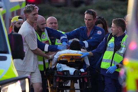 Emergency workers transport a person on a stretcher after a reported shooting at Bondi Beach, in Sydney.