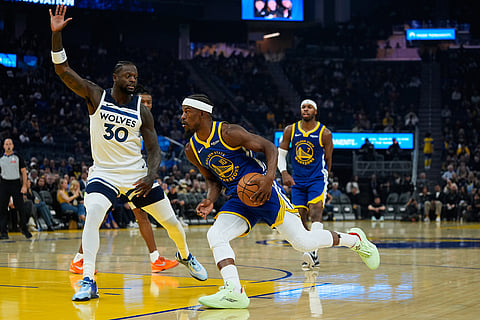 Golden State Warriors forward Jimmy Butler III (10) moves the ball while defended by Minnesota Timberwolves forward Julius Randle (30) during the first half of an NBA basketball game in San Francisco. 
