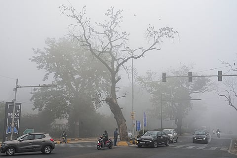 Vehicles move through fog on a cold winter morning, in New Delhi.