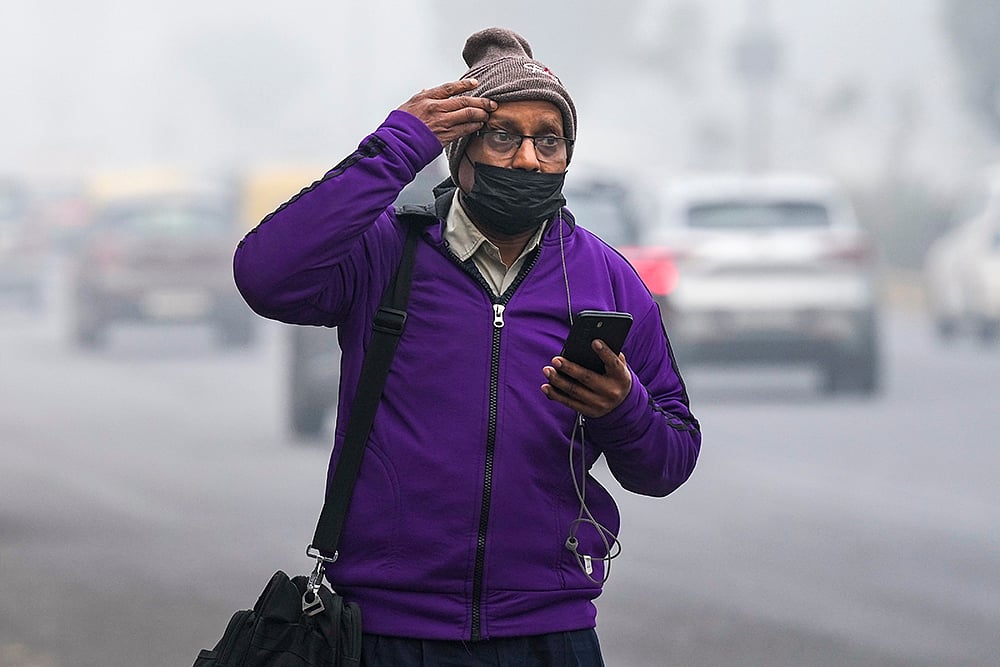 | Photo: PTI/Salman Ali : A pedestrian walks through fog on a cold winter morning, in New Delhi.