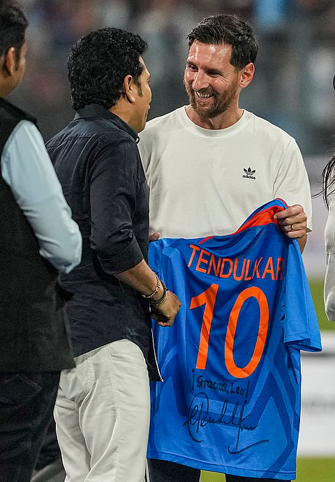 Argentine football superstar Lionel Messi, right, being presented an Indian cricket team jersey by cricket legend Sachin Tendulkar during an event as part of the 'GOAT India Tour 2025', at the Wankhede Stadium, in Mumbai.