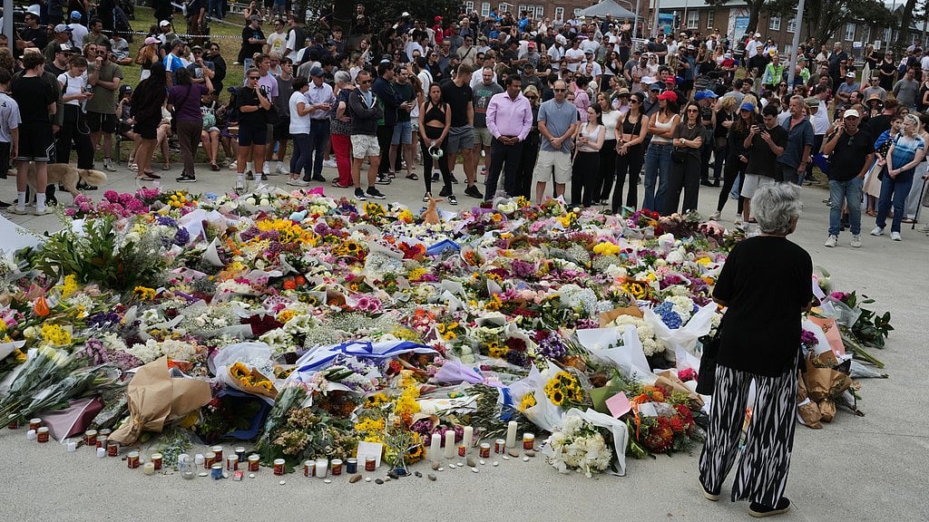 AP : People gather at a growing flower memorial to shooting victims outside the Bondi Pavilion at Sydney's Bondi Beach.