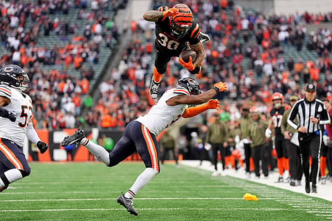 Cincinnati Bengals running back Chase Brown (30) hurdles Chicago Bears defensive back Kevin Byard III (31) on a run during an NFL football game, Nov. 2, 2025, in Cincinnati. 