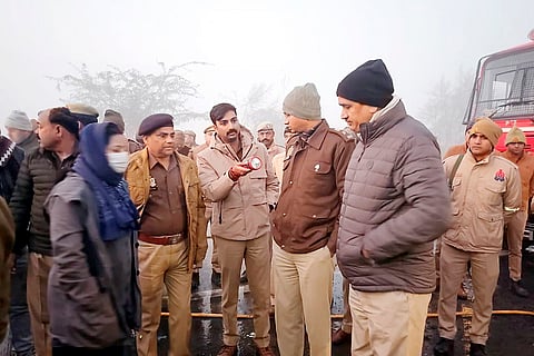 Police and rescue personnel gather at the site after a fog-hit pile-up involving buses and cars sparked fires on the Yamuna Expressway, in Mathura.