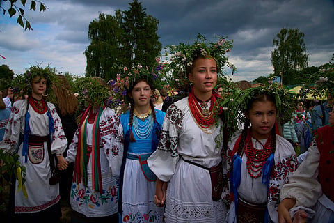 Young women dressed in traditional Ukrainian clothing dance in circle during a traditional midsummer celebration in Pyrohiv, Ukraine, outside of Kyiv, June 21, 2025. 