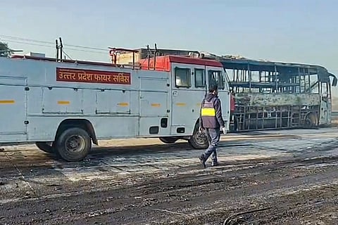 A Uttar Pradesh Fire Service tender is seen near a charred bus after a fog-hit pile-up involving buses and cars sparked fires on the Yamuna Expressway, in Mathura.