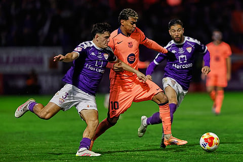 Barcelona's Lamine Yamal, center, vies for the ball with Guadalajara's Argus Moreno during the Copa del Rey soccer match between Guadalajara and Barcelona in Guadalajara, Spain.