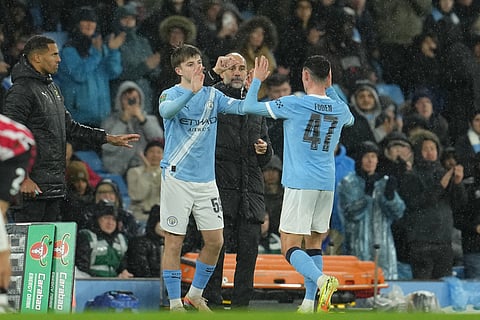 Manchester City's head coach Pep Guardiola substitutes Manchester City's Phil Foden with Manchester City's Charlie Gray, left, during the English League Cup soccer match between Manchester City and Brentford in Manchester, England.