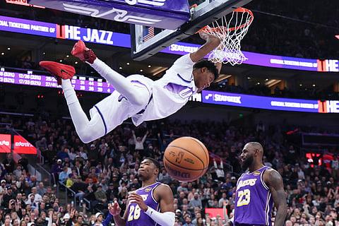 Utah Jazz guard Ace Bailey, top, hangs on the rim after a dunk against the Los Angeles Lakers during the second half of an NBA basketball game in Salt Lake City. 