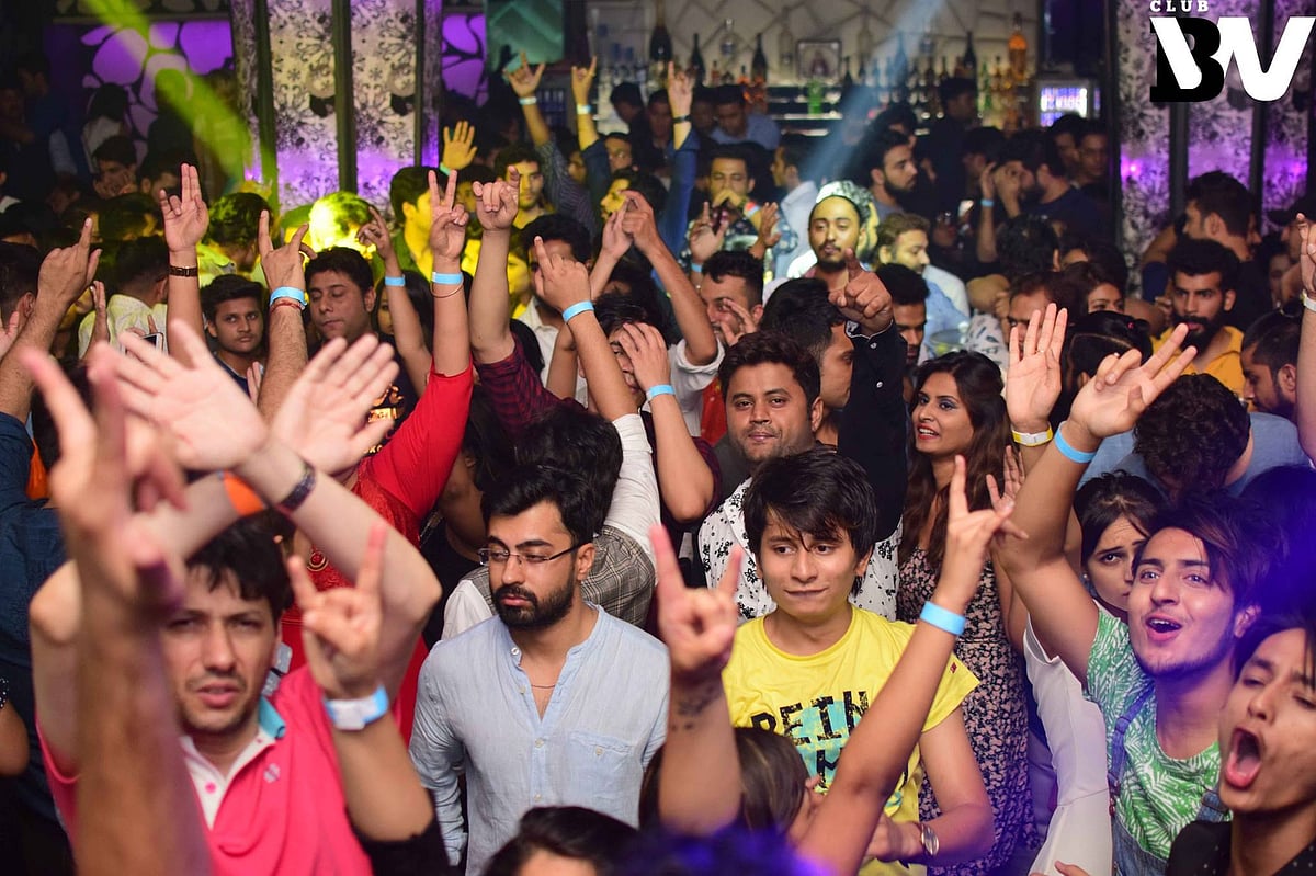 Crowd dancing and cheering at a lively club event in New Friends Colony