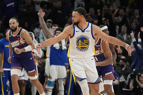 Golden State Warriors guard Stephen Curry celebrates a 3-pointer made by Warriors forward Jimmy Butler III against the Phoenix Suns during the second half of an NBA basketball game in Phoenix. 
