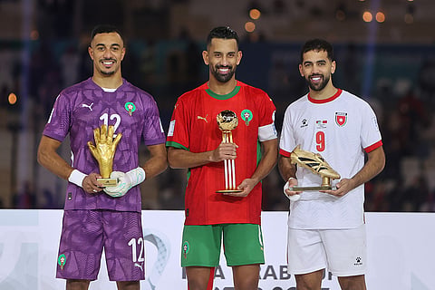 From left, Morocco's goalkeeper El Mehdi Benabid, best goalkeeper, Morocco's Mohamed Rabie Hrimat, best player, and Jordan's Ali Olwan, top scorer, pose with their trophies during a trophy ceremony end of the FIFA Arab Cup final soccer match between Morocco and Jordan, in Lusail, Qatar.