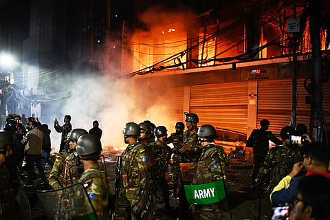 Bangladesh army stands guard at the premises of the Prothom Alo daily newspaper after angry protesters set it on fire after news reached the country from Singapore of the death of a prominent activist Sharif Osman Hadi, in Dhaka, Bangladesh.