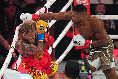 Anthony Joshua, right, punches Jake Paul during their heavyweight boxing match in Miami, Fla.