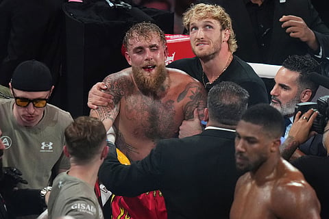 Jake Paul, center, reacts after losing the heavyweight boxing match against Anthony Joshua in Miami, Fla.