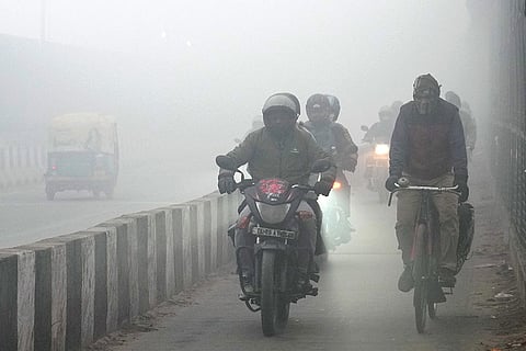 Commuters brave dense fog on a winter morning, in New Delhi.