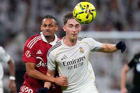 Real Madrid's Dean Huijsen, right holds of the challenge of Sevilla's Djibril Sow during the Spanish La Liga soccer match between Real Madrid and Sevilla in Madrid, Spain.