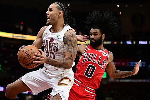 Cleveland Cavaliers guard Jaylon Tyson, left, goes to the basket against Chicago Bulls guard Coby White (0) in the second half of an NBA basketball game in Cleveland. 