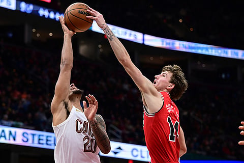 Chicago Bulls forward Matas Buzelis blocks a shot by Cleveland Cavaliers guard Jaylon Tyson in the second half of an NBA basketball game in Cleveland. 