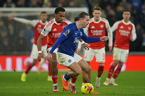 Everton's Jack Grealish, front, dribbles the ball past Arsenal's Jurrien Timber during the English Premier League soccer match between Everton and Arsenal in Liverpool, England.
