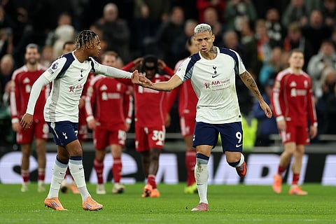 Tottenham's Richarlison, right, celebrates with teammates after scoring his side's opening goal during the English Premier League soccer match between Tottenham and Liverpool in London.