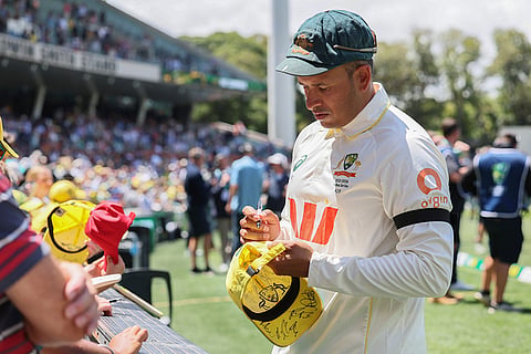 Australia's Usman Khawaja sign autograph to fans after they won the third Ashes cricket test match against England in Adelaide, Australia.