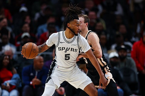 San Antonio Spurs guard Stephon Castle (5) dribbles against Atlanta Hawks guard Luke Kennard, right, during the first half of an NBA basketball game, in Atlanta. 