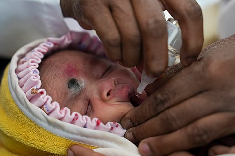 A child receives polio drops during the pulse polio immunisation programme at a government hospital, in Bengaluru.