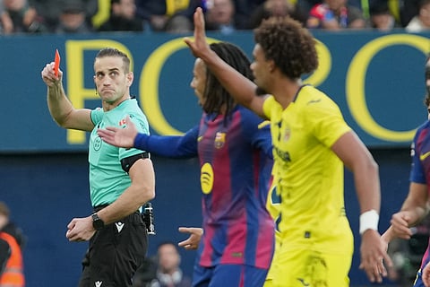The referee shows a red card to Villarreal's Renato Veiga, right, during the Spanish La Liga soccer match between Villarreal and Barcelona in Villarreal, Spain.