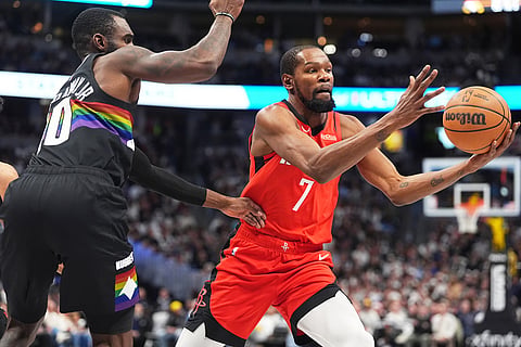 Houston Rockets forward Kevin Durant, right, pulls in a loose ball as Denver Nuggets guard Tim Hardaway Jr. defends in the second half of an NBA basketball game in Denver.