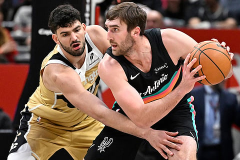 Washington Wizards forward Tristan Vukcevic, left, guards against San Antonio Spurs center Luke Kornet, right, during the first half of an NBA basketball game in Washington. 