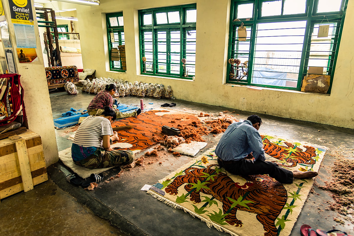 Shutterstock : Colourful paintings carpet are being prepared for sale by Indian rural Tibetan worker. Handicrafts are rural Industry in Himachal Pradesh. 