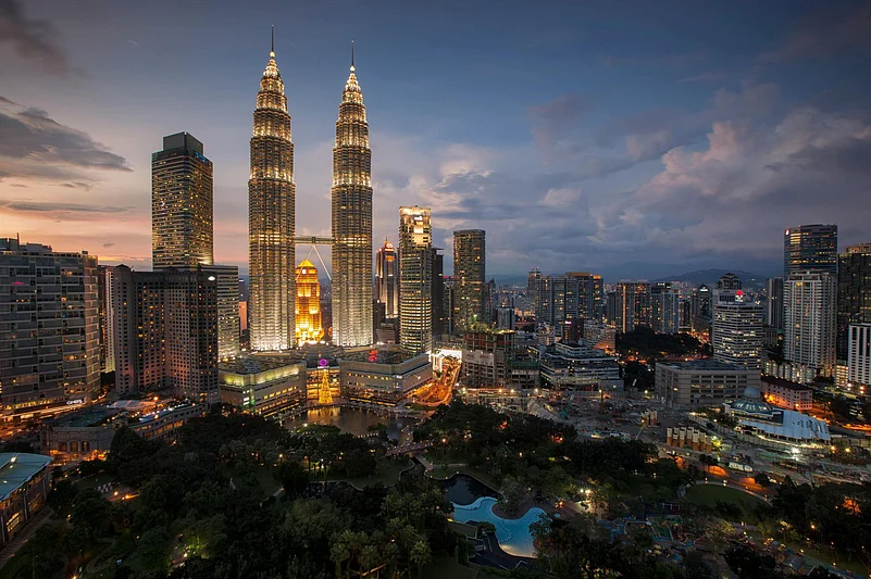 The Petronas Twin Towers illuminated at night against the Kuala Lumpur skyline
