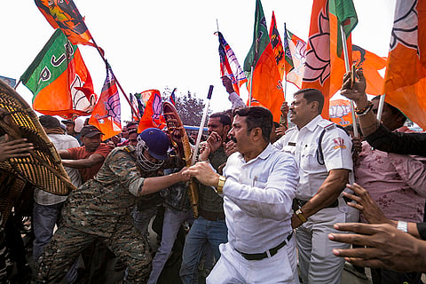 Security personnel try to stop BJP supporters during a protest against the alleged killing of a Hindu youth in Bangladesh, near Howrah Bridge.