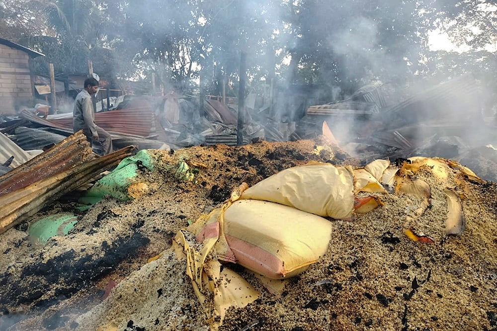 | Photo: PTI : Smoke billows out from a vandalised area following violent protests demanding eviction of encroachers from tribal belts, at Kheroni, in Karbi Anglong district, Assam.