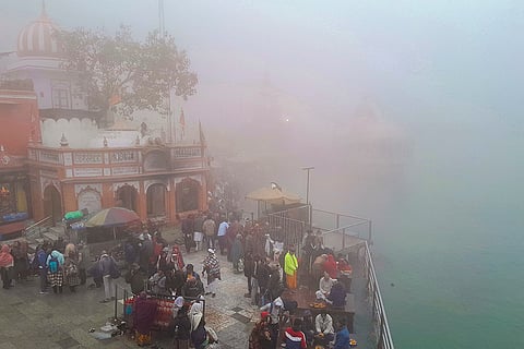 Devotees gather to offer prayers amid dense fog at Har Ki Pauri, in Haridwar.