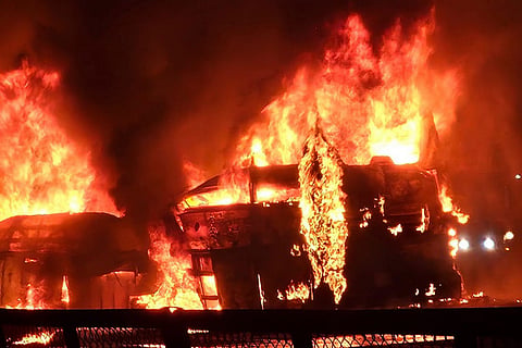Flames and smoke billow out after a bus caught fire following a collision with a speeding truck, in Chitradurga. At least nine persons were killed in the incident.
