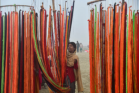A worker sells colourful holy threads at the Sangam on a winter morning, in Prayagraj.