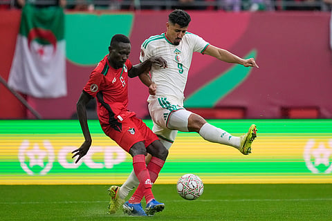 Sudan's Mustafa Karshom, left, challenges for the ball with Algeria's Baghdad Bounedjah during the Africa Cup of Nations group E soccer match between Algeria and Sudan in Rabat, Morocco.