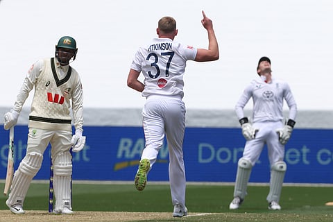 England's Gus Atkinson, center, celebrates the wicket of Australia Usman Khawaja, left, during their Ashes cricket test match in Melbourne.